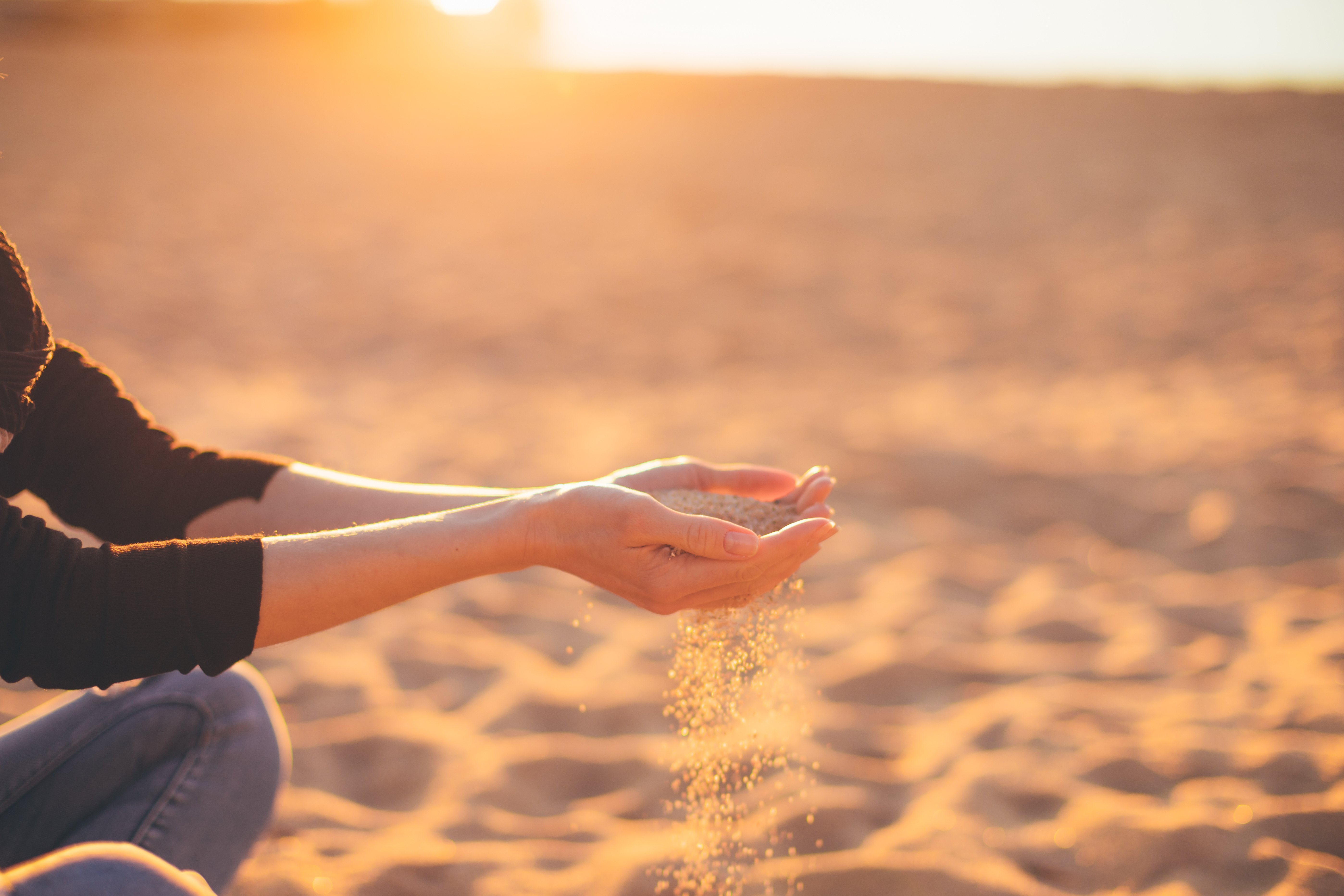 Sand flowing through the hands - zen, relax, meditation, peace of mind and time is running out concept